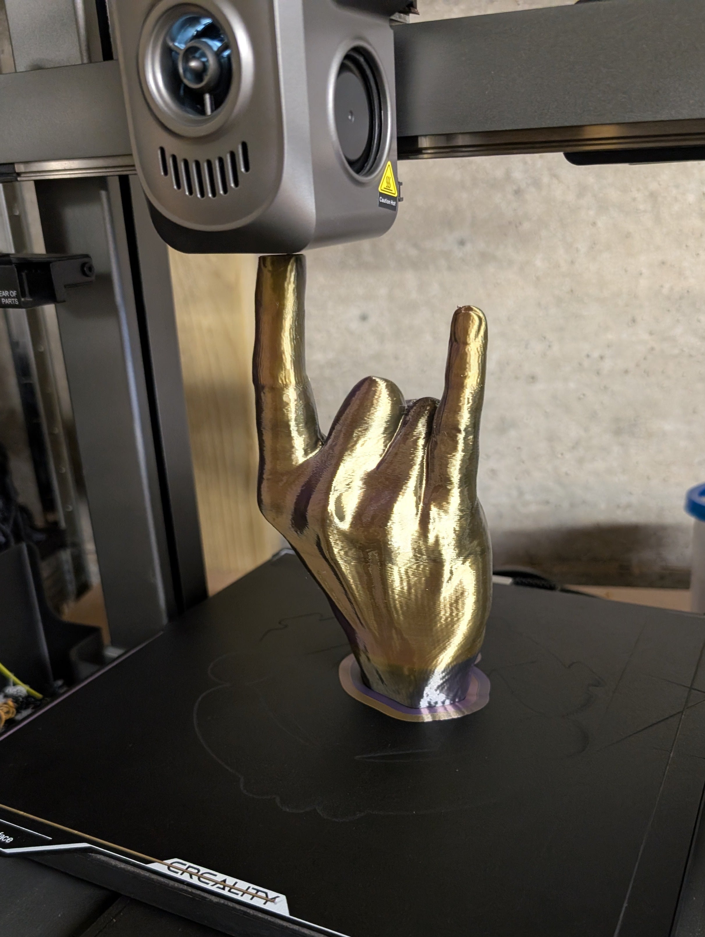 Gold hand sculpture on a 3D printer during printing process